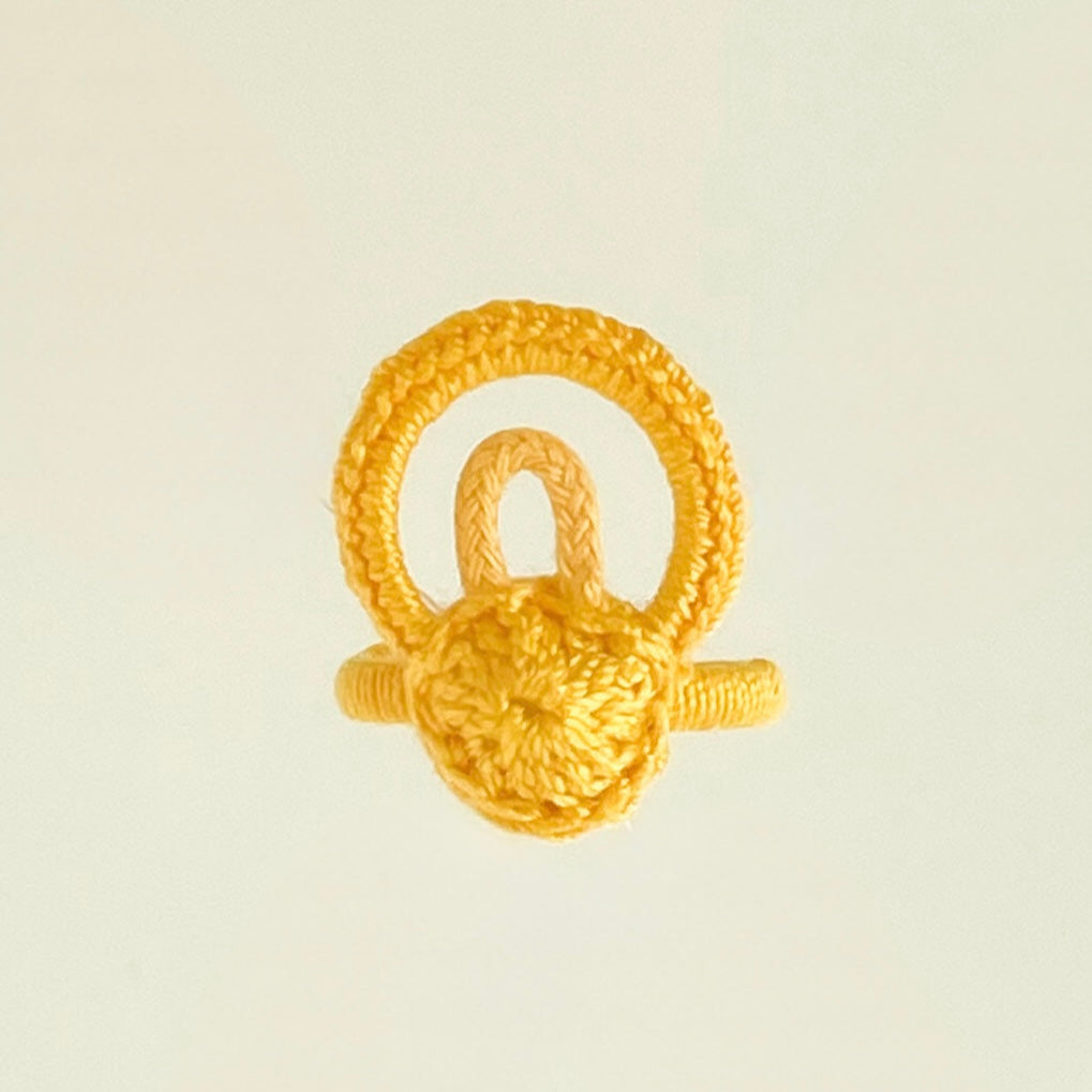 Golden yellow artisan crochet ring, exclusive handmade jewelry from Chicago, captured from overhead with vibrant color