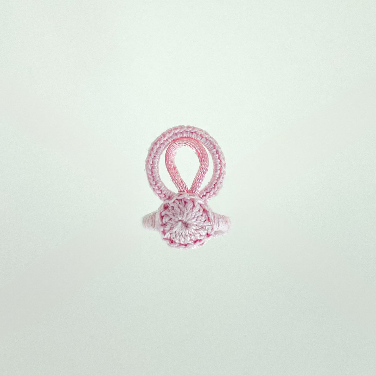 Top view of the rose-colored crochet ring from the Blossom collection, showcasing its floral-inspired design and refined stitchwork.