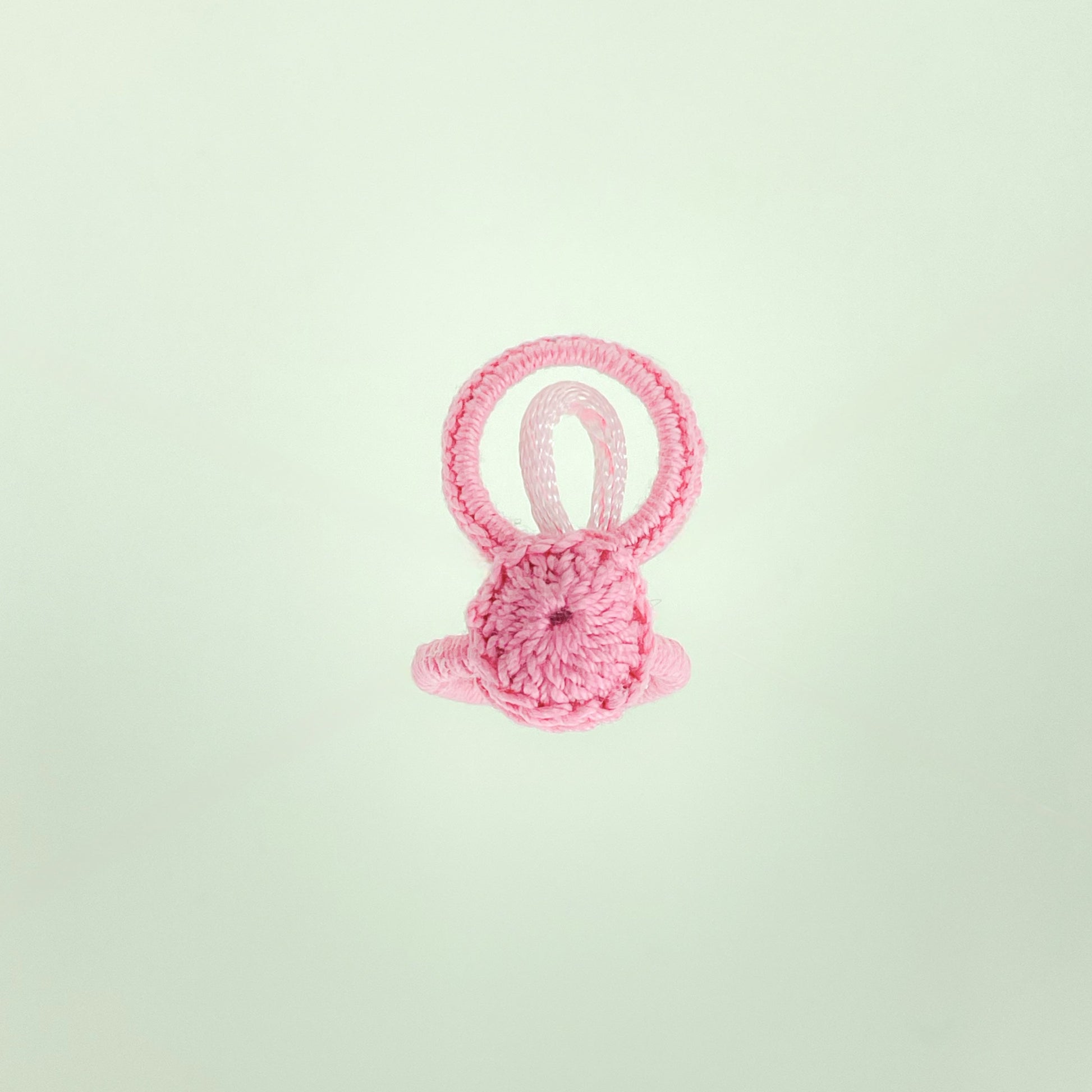 Top view of the Blossom collection crochet ring in light pink, featuring delicate circular stitching and soft texture.