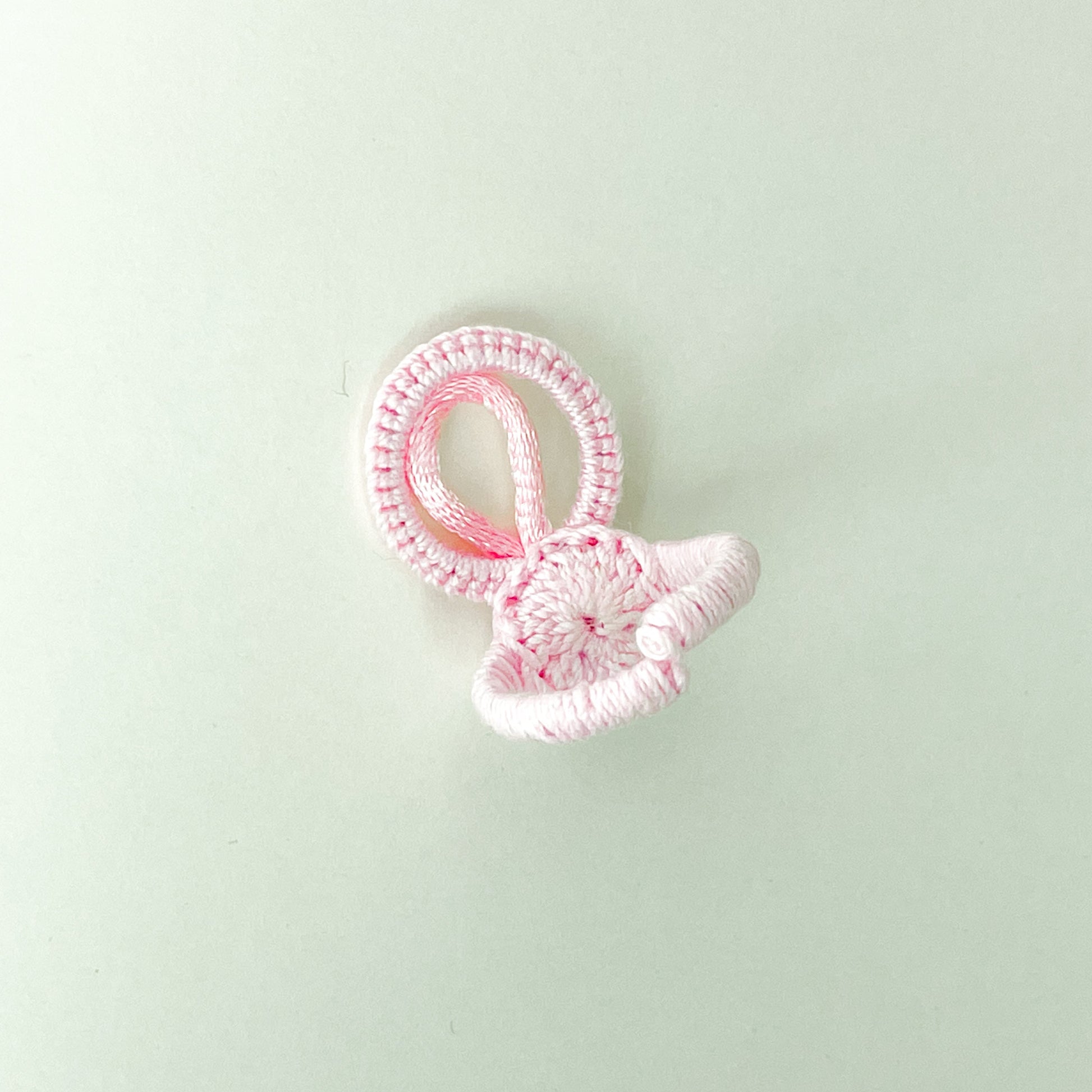 Back of the rose-colored Blossom collection crochet ring, highlighting the craftsmanship and neat finish of the adjustable band.
