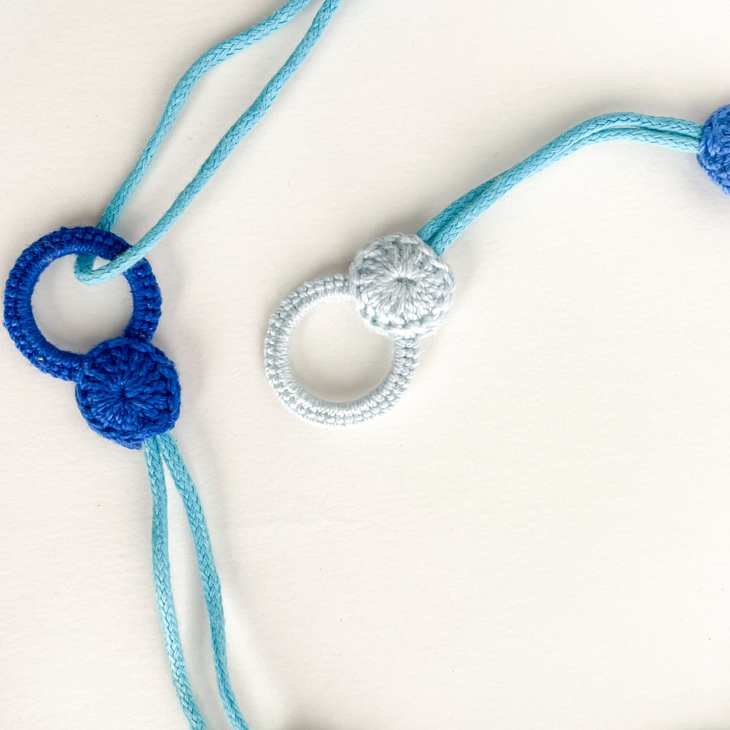 Blossom collection necklace clasp with a crochet loop that receives the button to fasten the necklace.