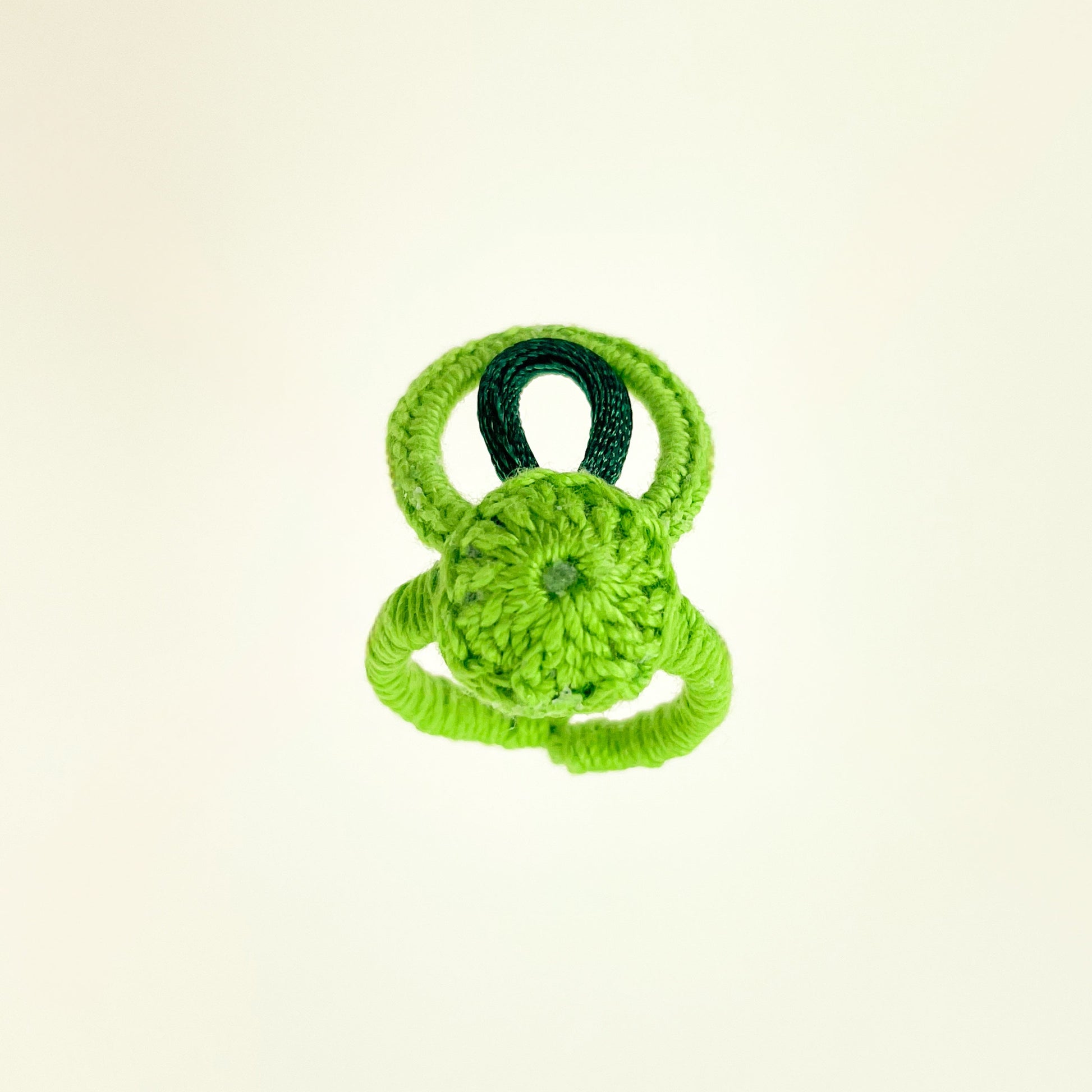 Green handmade crochet ring from the Blossom collection showing its texture and form.
