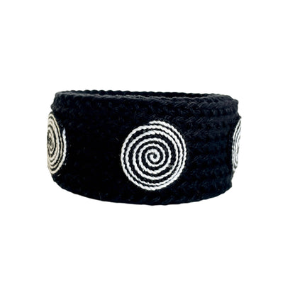 Black Spiralis crochet bracelet with black and white spiral design on a white background.