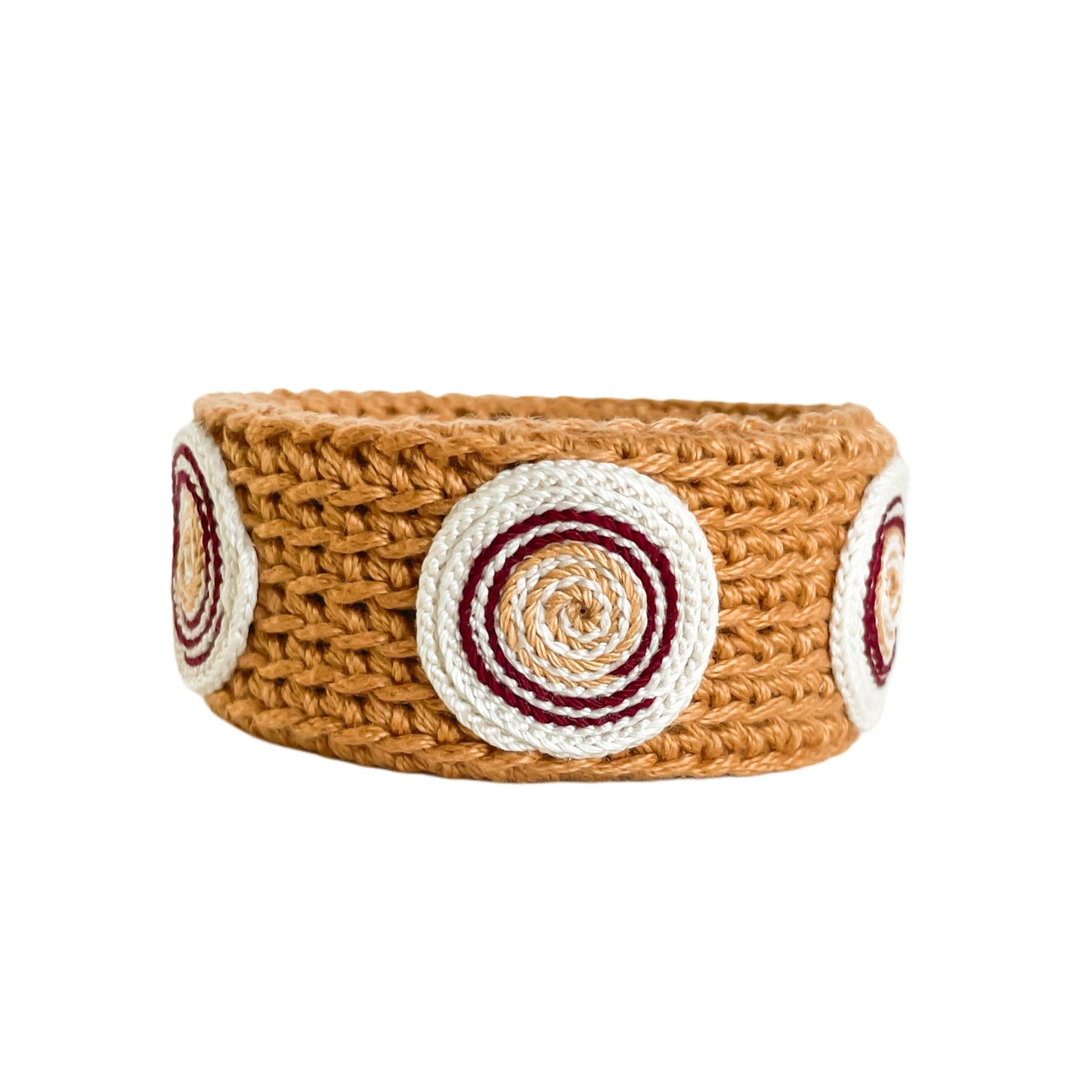 Amber Spiralis crochet bracelet with burgundy, Ivory and gold spiral design on a white background.