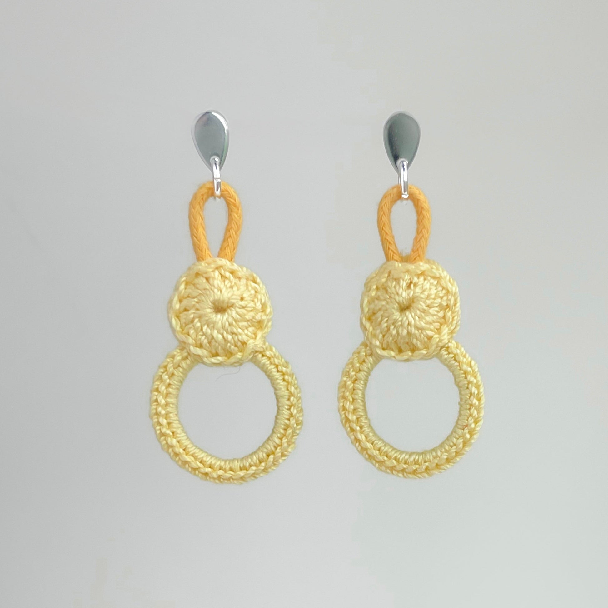Handmade yellow crochet earrings with double circle design.