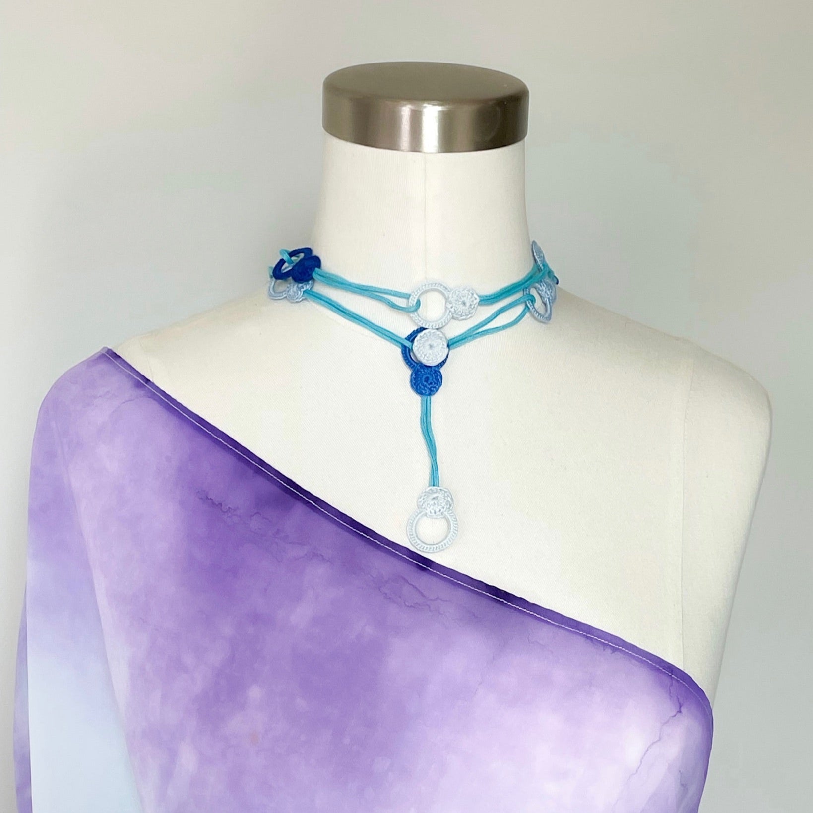 Handmade crochet necklace worn as a choker, soft cotton thread wrapped close to the neck with ends draping forward.