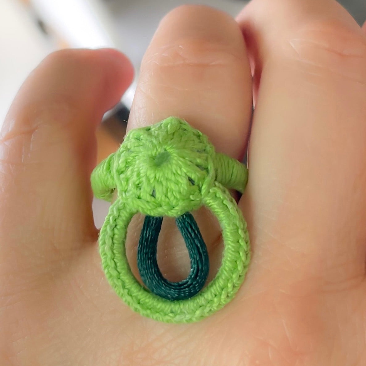 Green crochet ring, artisanal and modern, on hand