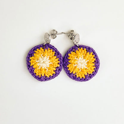 A close up of Paris dangle earrings. Small round earrings, colours: Wildberry, Gold dust,  and cornsilk.