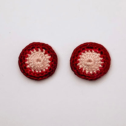 A close up of Kirk stud earrings. Small round earrings, colours: ivory, ruby and currant.