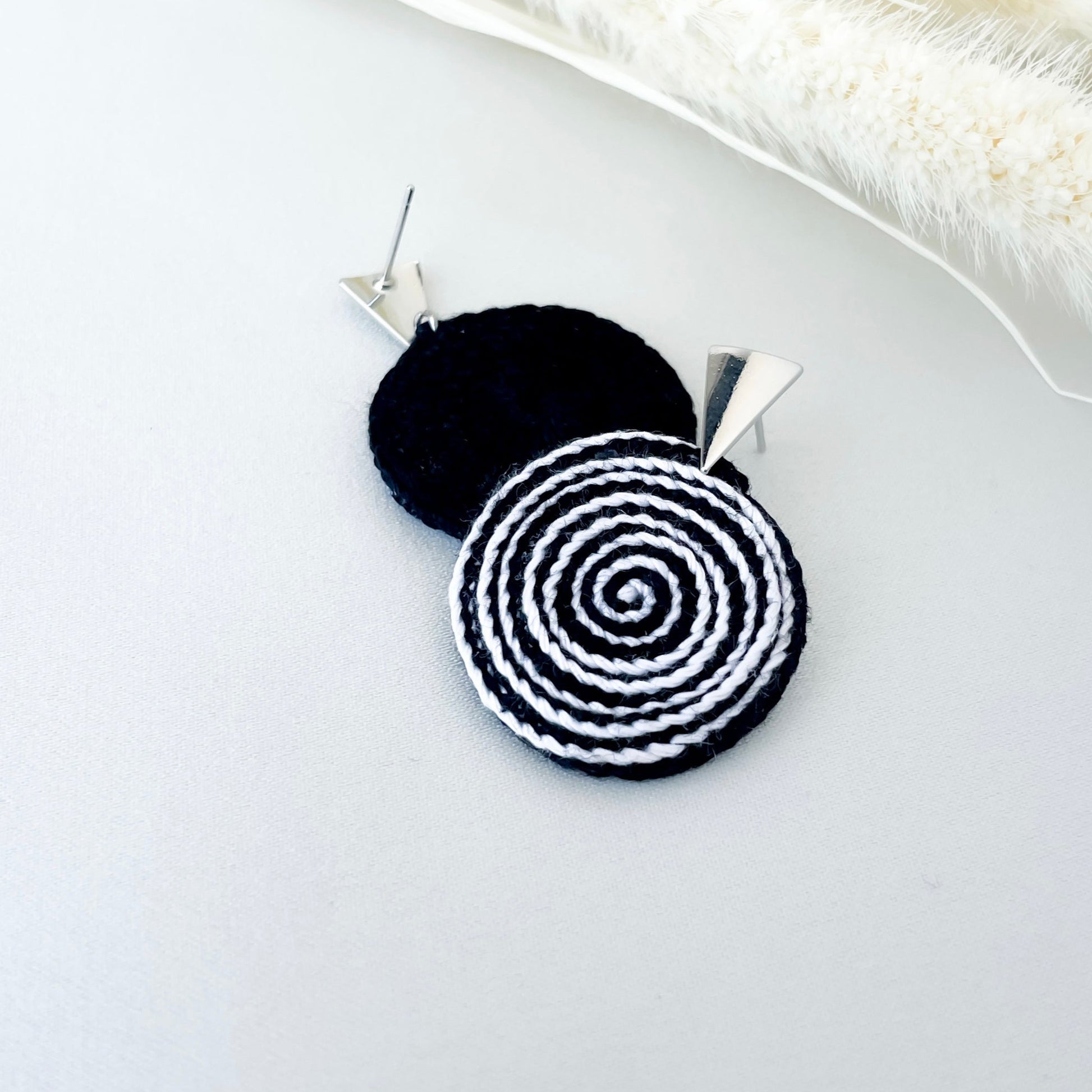 Side view of black and white crochet spiral earrings, lightweight and modern.