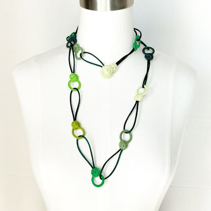 Green tones looped crochet necklace on mannequin with layering effect