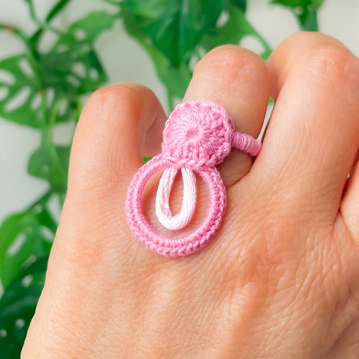 Light pink crochet ring on hand, inspired by floral shapes