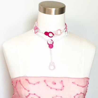 Rose adjustable crochet necklace on mannequin worn as a choker, soft cotton thread wrapped close to the neck with end draping forward