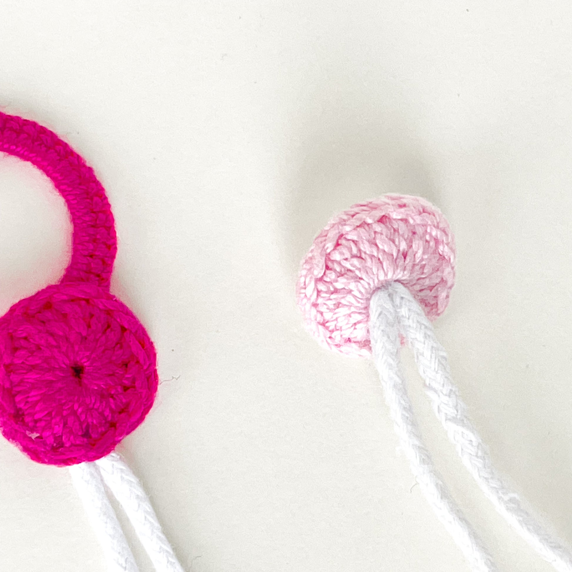 Back view of the crochet button showing how it’s attached to the Blossom necklace in pink tones