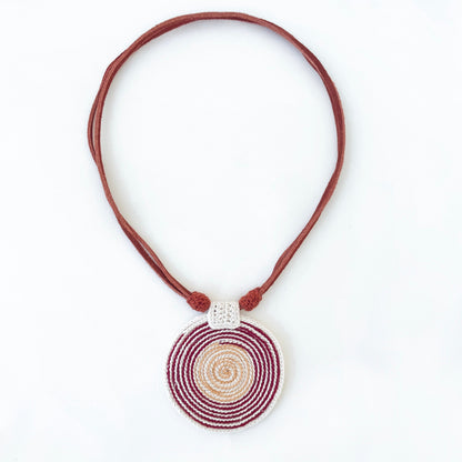Necklace with a spiral pendant in burgundy, Ivory and gold with vegan suede adjustable straps on a white background.  