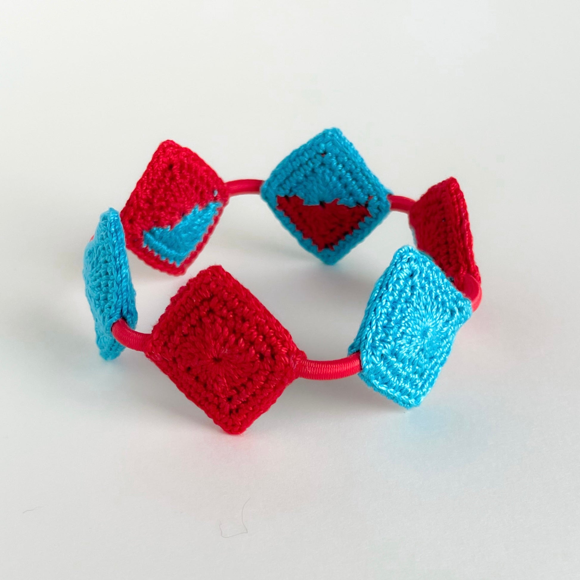 Reverse view of handmade Tessera geometric crochet bracelet by Crochet by Heart featuring Caribbean blue (turquoise) and red diamond crochet motifs.
