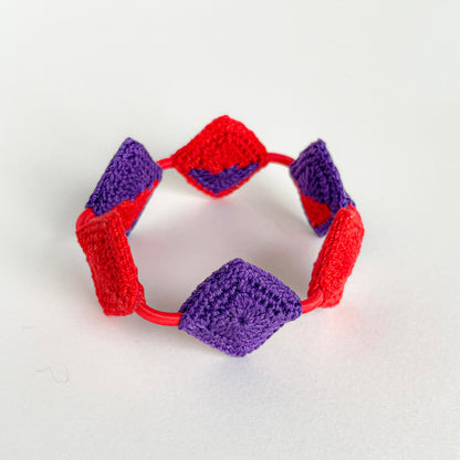 Reverse view of handmade Tessera geometric crochet bracelet by Crochet by Heart featuring red and violet diamond crochet motifs.
