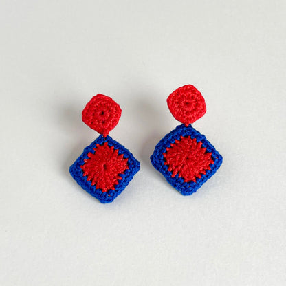 Pair of red and blue Tessera crochet earrings on a white background