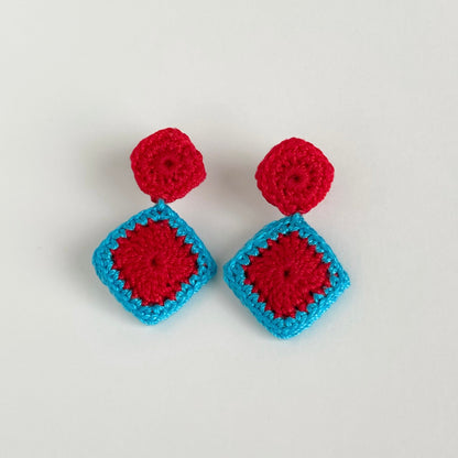 Pair of red and caribbean blue crochet earrings on a white background