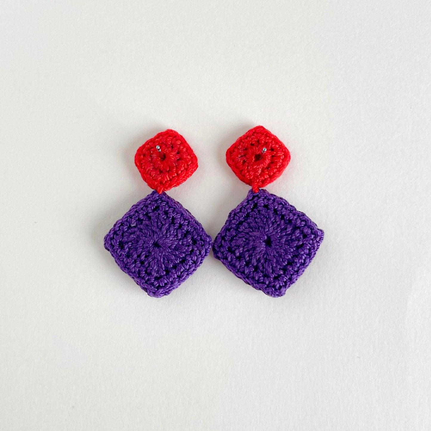Back view of the Tessera crochet earrings with red tops and purple squares on a white background by Crochet by Heart.