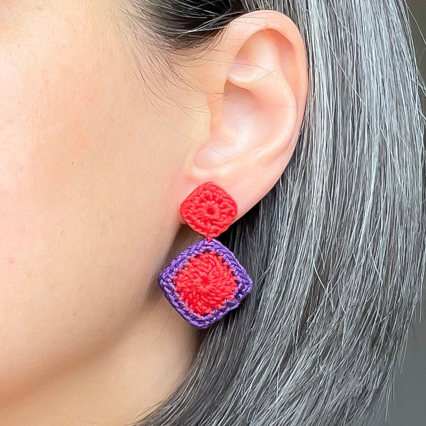 Tessera geometric crochet earrings worn on the ear featuring red and purple diamond crochet design by Crochet by Heart