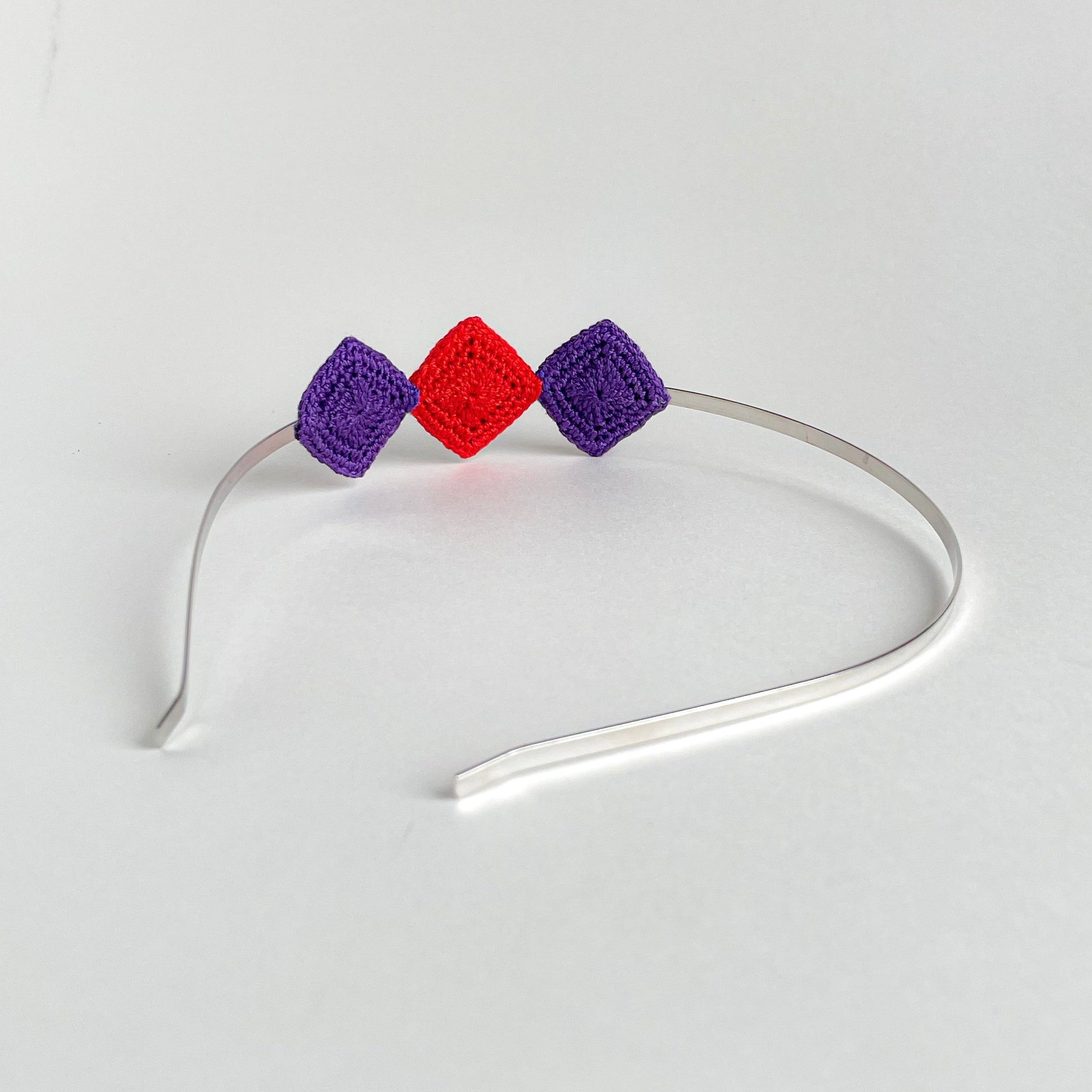 Back view of Tessera handmade crochet geometric headband with turquoise and red diamond motifs on silver metal band