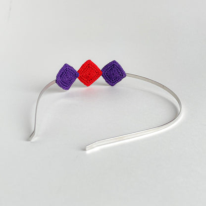 Back view of Tessera handmade crochet geometric headband with turquoise and red diamond motifs on silver metal band