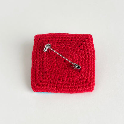 Back view of the Tessera Pin in red on a white background by Crochet by Heart.