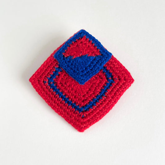 Handmade crochet geometric brooch in red and royal blue with layered square motifs