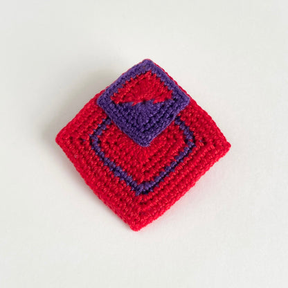Tessera handmade crochet geometric brooch in red and violet with layered square motifs by Crochet by Heart.