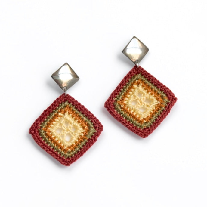 TRAMA diamond-shaped crochet earrings with yellow butter centres, ginger and moss borders, copper edges and silver-tone square studs.