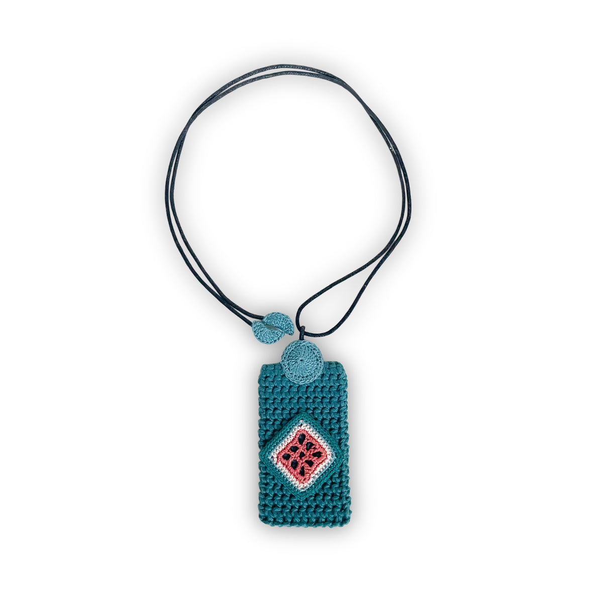 TRAMA crochet necklace with a teal rectangular pendant, a clay, cream and blue jade diamond motif, and a black cord on a white background.