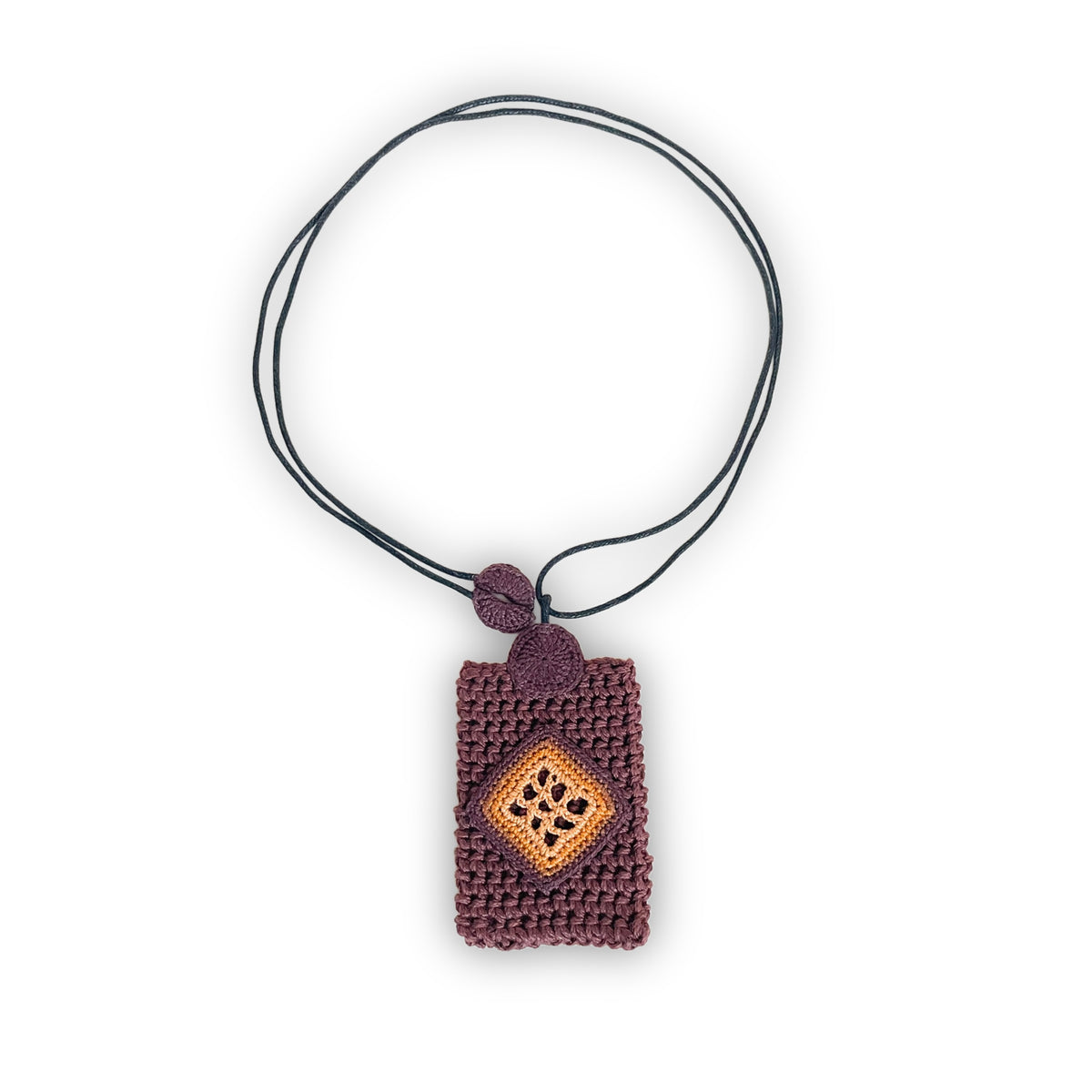 TRAMA crochet necklace with a brown rectangular pendant, a chocolate, ginger and marigold diamond motif, and a black cord on a white background.